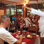 Photo.- page 84 | Miguel Ventura – Caption: Take a trip to South America at Madeira Bistro, which specializes in rodízio (all-you-can-eat steak and other skewered proteins).