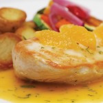 Photo.- page 69 | Arlen Rodriguez – Caption: The Pollo al Limoncello puts a tangy twist on the traditional chicken breast, here served in an orange-limoncello sauce with sides of rosemary potatoes and grilled vegetables.