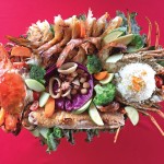 Photo.- page 84 | Courtesy Mango Deck – Caption: The Mariscada at Mango Deck, located right on Médano Beach, is a perfect date night dinner for two. The platter features lobster, shrimp, fish, crab, scallops, octopus, and calamari, and is served with rice and vegestables.