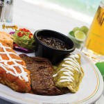 Photo: - page 82 | Courtesy Mango Deck – Caption: The hearty Mexican plate at Mango Deck includes chile relleno, flank steak, and a chicken enchilada in green sauce, as well as rice, beans, and guacamole.