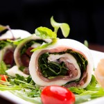 Pettola di mozzarella: ​Homemade Mozzarella roll stuffed with cherry tomato, arugula, Prosciutto di Parma served with black olive tapenade and basil pesto.​