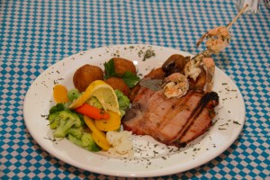 Signature Black Forest Schnitzel: smoked pork chop with skewered shrimp, choice between pork or chicken schnitzel, served with steamed vegetables with hollandaise sauce and pomme croquettes (mashed potatoes lightly breaded and fried).