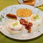 eggs Benedict.- with canadian loin drenched in hollandaise sauce with fried plantain, hash brown potatoes, bacon or sausage