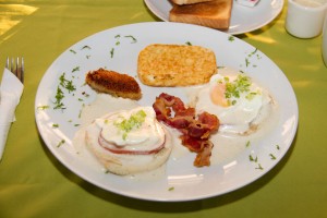 eggs Benedict.- with canadian loin drenched in hollandaise sauce with fried plantain, hash brown potatoes, bacon or sausage