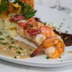 Jumbo Shrimps Duo of Moles.- white & black mole served with plantain purée & baby vegetables.