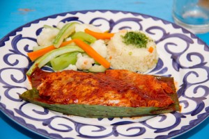 Pescado TikinXic.- Basted in achiote (ground annatto seeds, spices, tomatoes) & grilled in a banana leaf.