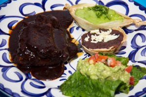 Costilla de Puerco en salsa de tamarindo.- Oven roasted sholder spare rib, smothered in a delicious smokey chile & tamarindo adobo. A great sweet & sour flavor. Served with fresh cilantro mashed potatoe, beans & guacamole