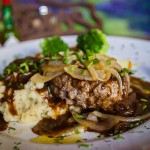 Hamburger steak with grilled onions, garlic chive mashed, potatoes and brown gravy.