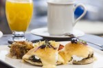 Huevos benedictinos – Moffin, tocino canadiense, salsa holandeza y papa rayada