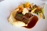Seared Short Rib – Braised Beef Short Ribs. Served with truffled mashed potatoes, organic vegetables and cashew nuts. Served with a sauce of pasilla chili