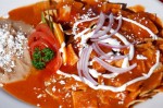 Chilaquiles Rojos – Soft chips with red sauce with chicken, served with beans, Sour cream and cheese